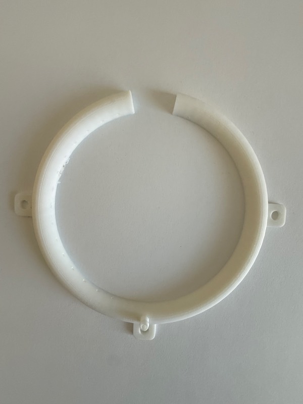 An early printed ring on a white table, with a clean break across the top where the seam split.