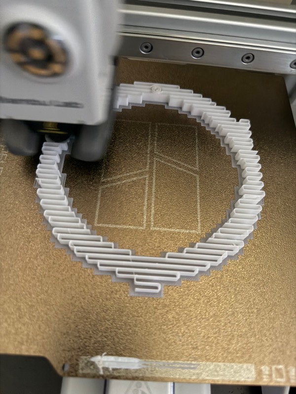 The ring's first layers on a printer bed, showing the zig-zag channel that runs around the inside of the wall.